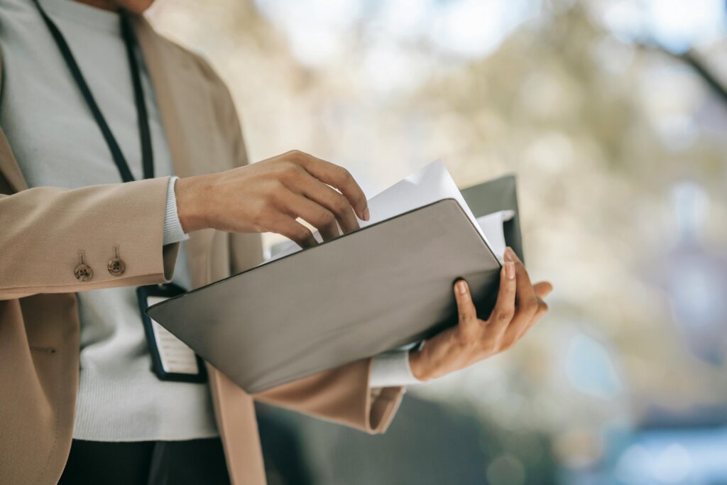 person holding a black folder with a year end checklist paper inside